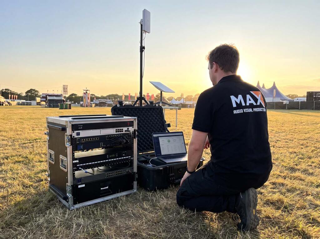 WiFi Mesh & IT Infrastructure for Remote Events: The 2026 Connectivity Playbook 3 Tech_kneeling_beside_rack_Maxavp_tech