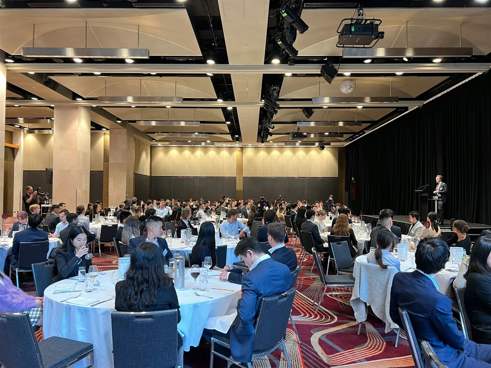 Guests seated at tables during a business presentation