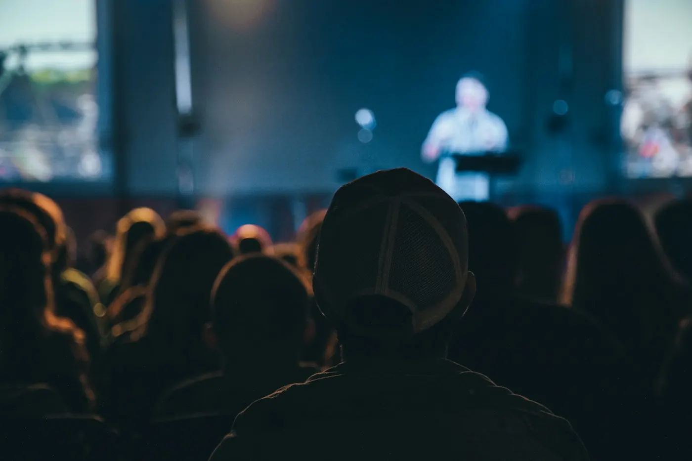 Audience member watching a presenter on a conference stage