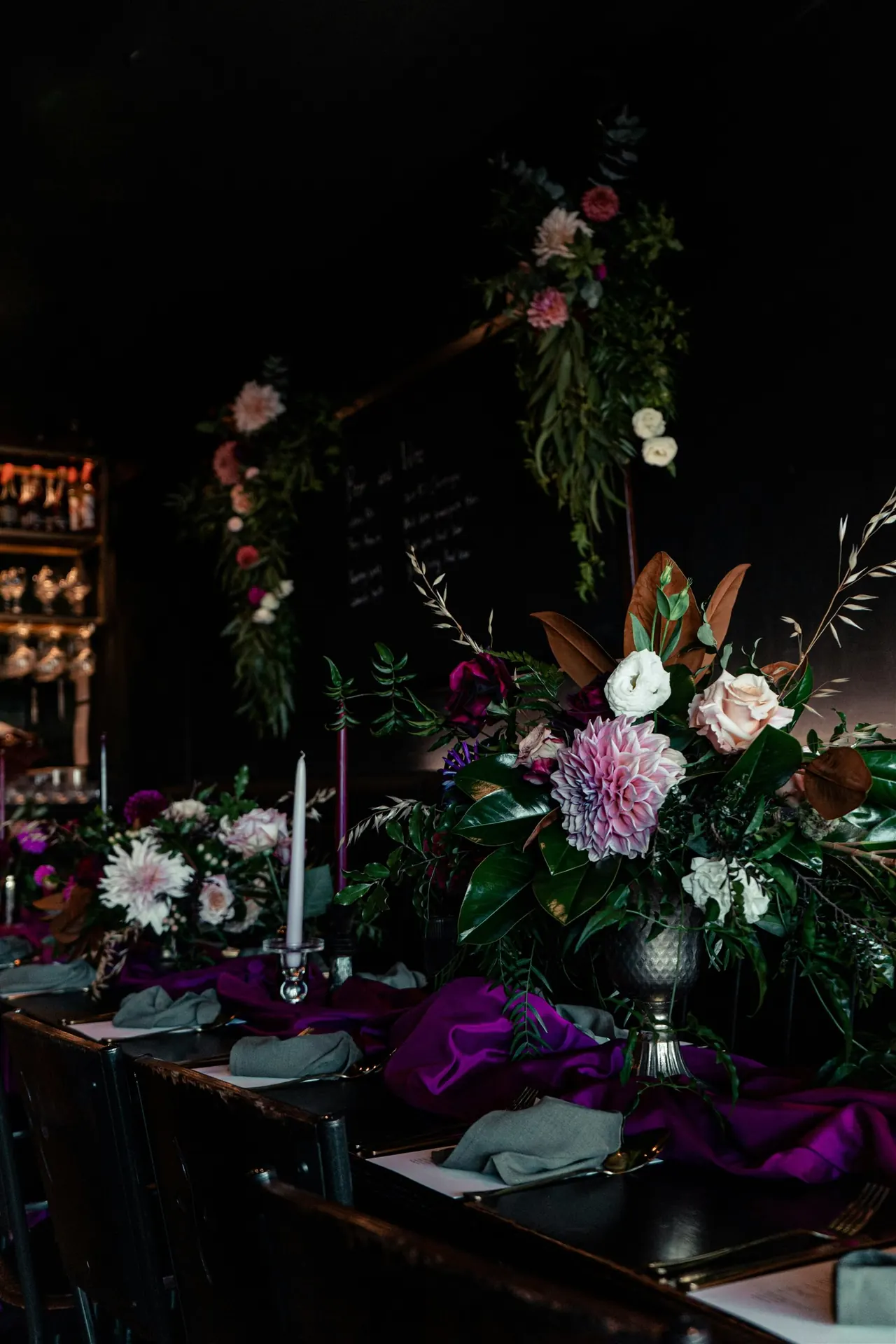 Richly colored floral centerpiece and dramatic reception table styling